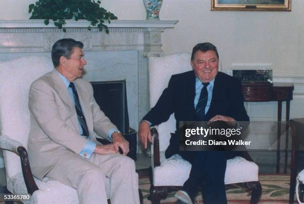 President Reagan chatting with W. German CSU Party leader Franz Josef Strauss, in Oval Office, sitting in front of Swedish ivy plant adorned...