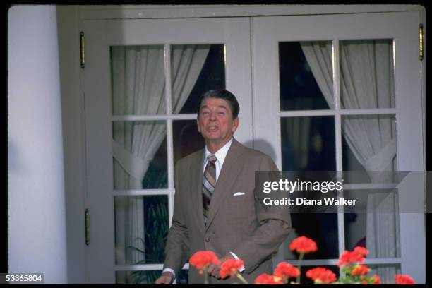 President Reagan poised on WH colonade, answering questions from press on Nicaragua, after Rose Garden ceremony.