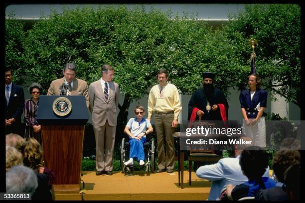 President Reagan speaking at Captive Nations Day proclamation signing ceremony in WH Rose Garden, with VP Bush .