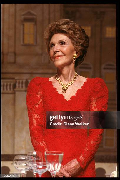 Nancy Reagan, decked out in red lace dress & gold earrings & necklace set, at "president's dinner" .