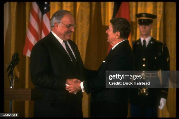 President Reagan shaking hands warmly with W. German Chancellor Helmut Kohl, at WH.