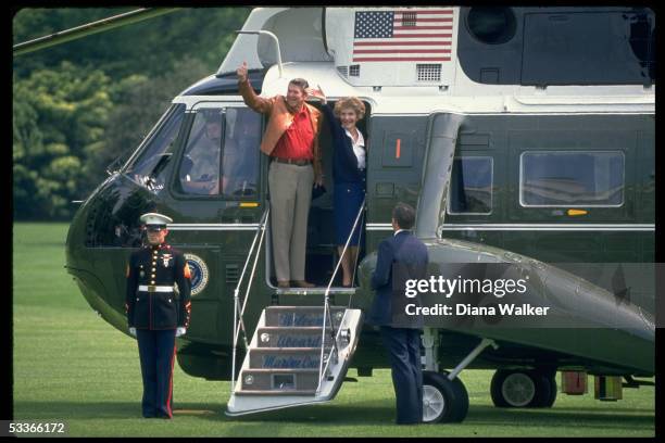 President & Nancy Reagan waving, he giving thumbs-up gesture, before boarding Marine One copter, leaving WH for Camp David.