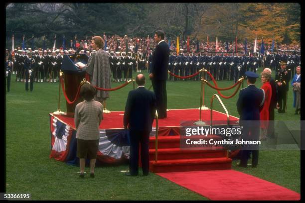 President Reagan with British PM Thatcher officiating at WH arrival fete, with Nancy Reagan & Denis Thatcher at far R.