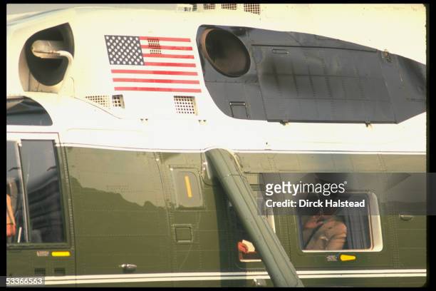 President Ronald Reagan waving through window of helicopter Marine One, departing WH.