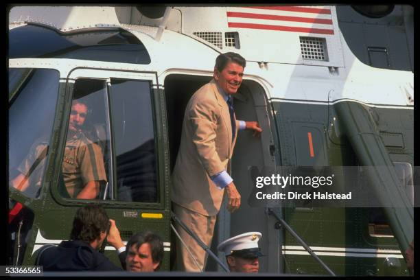President Ronald Reagan in doorway of helicopter Marine One, with pilot visible, departing WH.
