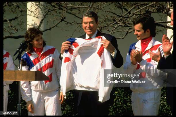 President Ronald Reagan , holding Olympic jacket with members of US Olympic team Bonnie Blair & Brian Boitano .; 1988.