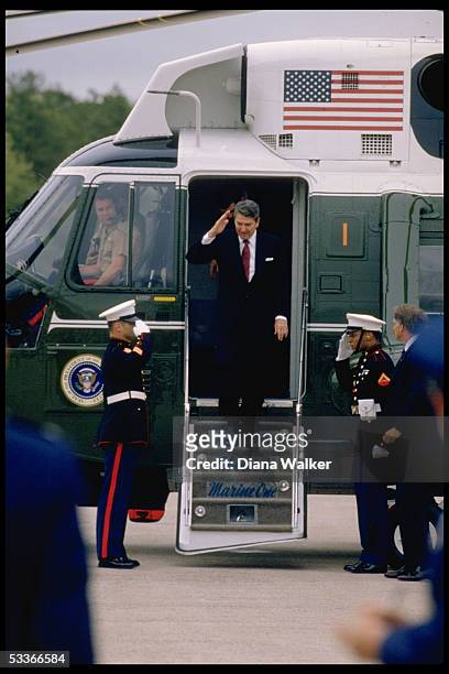 President Reagan returning salute of honor guard types, standing on steps of Marine One, arriving in Hartford, CT.