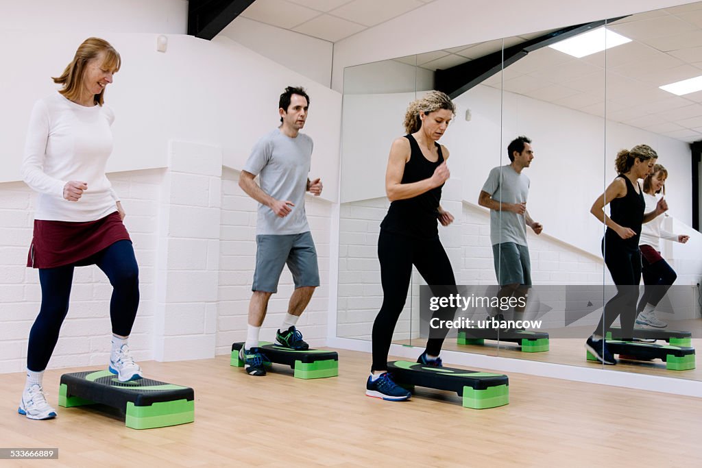 Adult step aerobics class in an exercise studio
