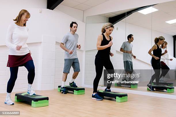 adult step aerobics class in an exercise studio - leisure facilities stock pictures, royalty-free photos & images