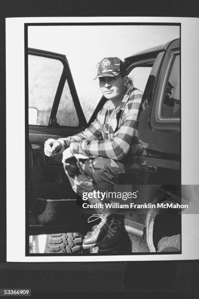 Green Bay Packers offensive lineman Tony Mandarich, sporting hunting clothes, as he sits in pickup truck with door open near home.