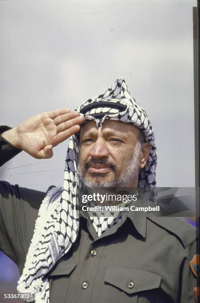 Leader Yasser Arafat saluting upon arriving for the OAU meeting.