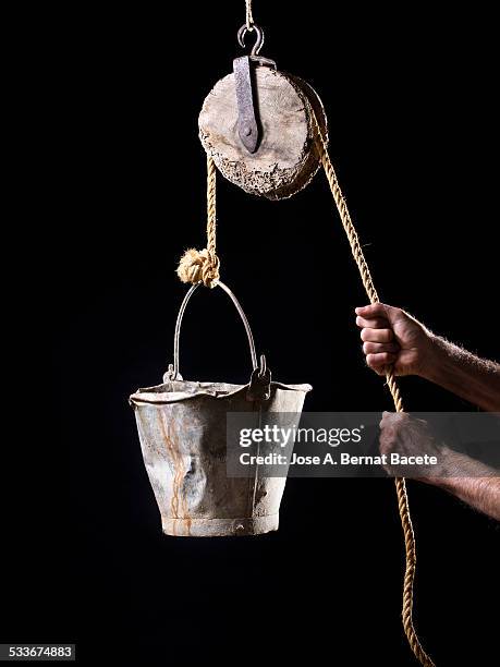 hands of a man pulling strongly a rope - polea fotografías e imágenes de stock