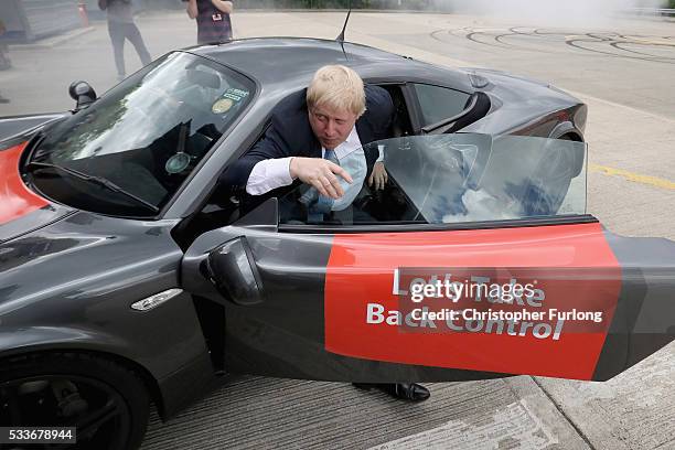 Boris Johnson MP emerges from a sports car after it performed 'donuts' during a visit to Ginetta Sports cars as part of the Brexit Battle Bus tour in...