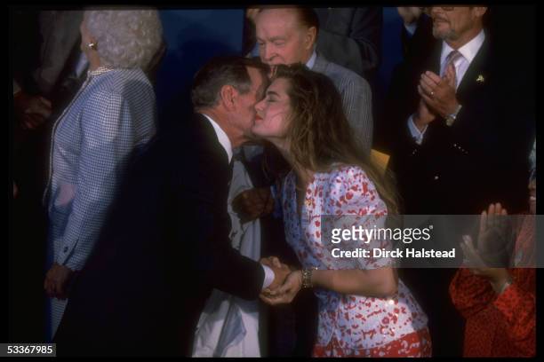 President Bush kissing Brooke Shields, with Bob Hope among cast during taping of USO 50th anniv. TV special "Welcome Home America".