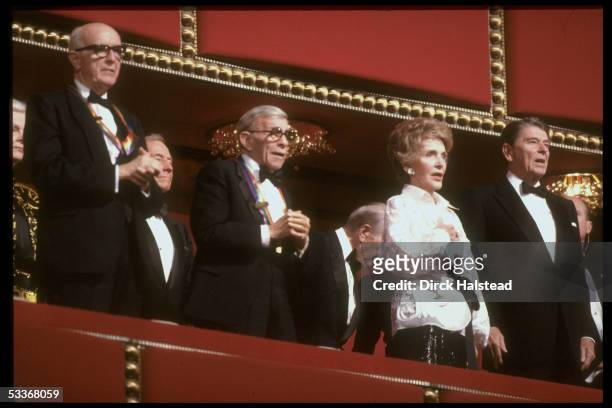 Kennedy Center honorees: former President Ronald Reagan & wife Nancy, actor George Burns, & Roger Stevens, singing.