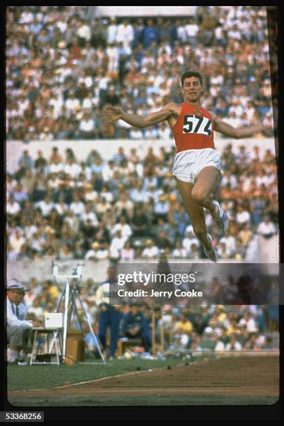 Soviet long jumper Igor Ter-Ovanesyan leaping through air probably during 1960 Olympics.