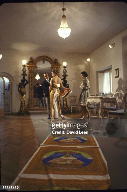 Designer Emilio Pucci, with model, working on elegant evening gown in his palazzo showroom.