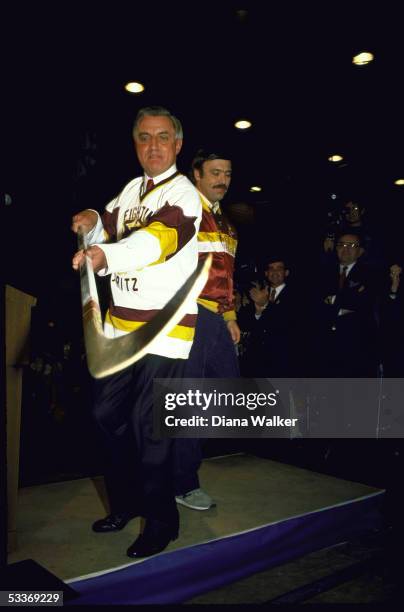 Democratic President candidate Walter F. Mondale wearing hockey shirt wielding hockey stick while campaigning at University of Minnesota.