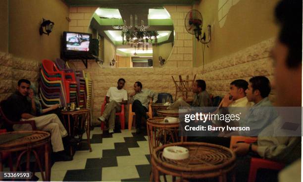 Cafe patrons watching an al-Jazeera satellite TV broadcast, tuning in to the Qatari channel for the latest news bulletin on the Israeli/Palestinian...