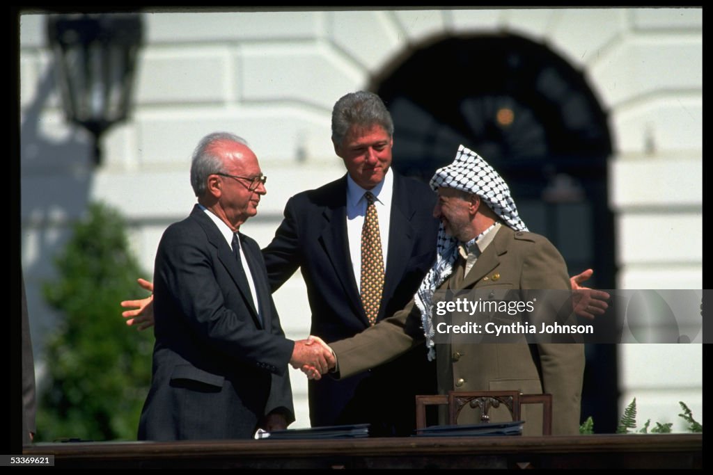 Pres. Clinton (C) smiling as PLO chmn. Yasser Araf