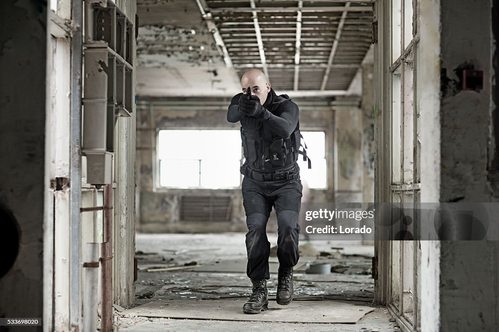 Masculino militares swat membro de equipe segurando arma no Armazém abandonado