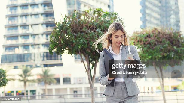 businesswoman texting in dubai - expatriate stock pictures, royalty-free photos & images