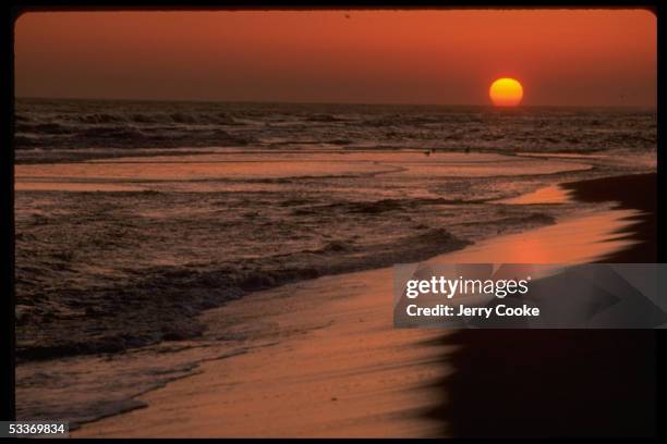 Beautiful of sun setting over unidentified beach.