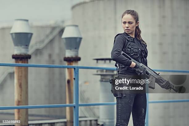 feminino militares swat membro de equipe segurando um rifle no armazém abandonado - armamento - fotografias e filmes do acervo