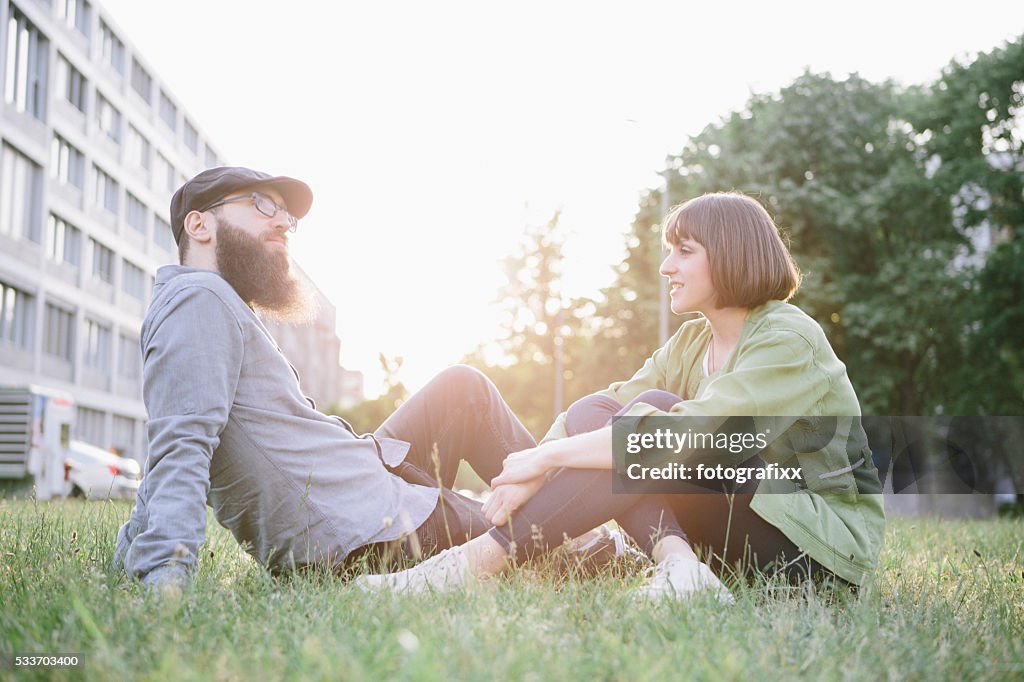 Hipster barbudo e namorada relaxe no parque, tenha um descanso