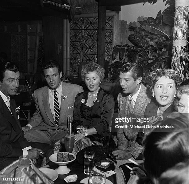 Actress Barbara Stanwyck with husband Robert Taylor and Robert Stack attend a cocktail party for the Hollywood Press Club in Los Angeles,CA.