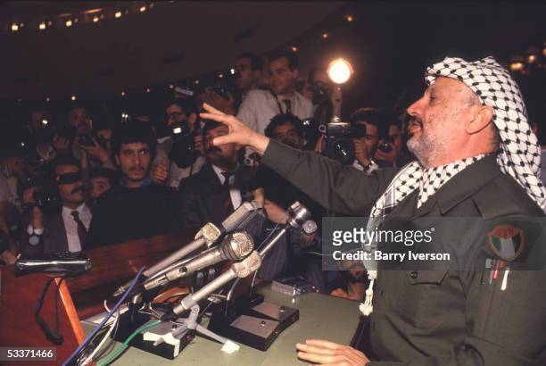 Palestine Liberation Organization leader Yasser Arafat speaking to press during a gathering of the Palestinian National Council.