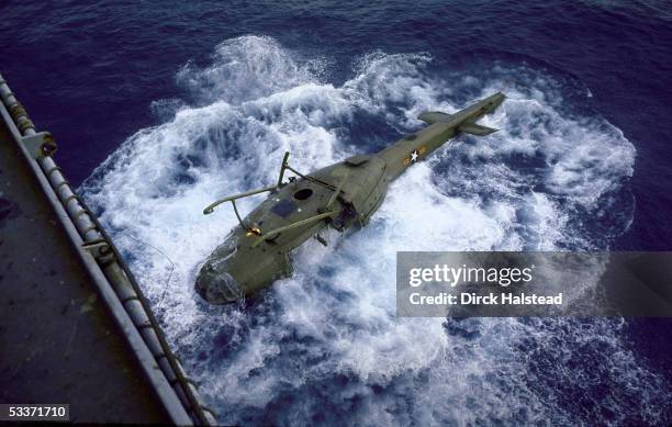 American helicopter sinking after being dumped overboard from aircraft carrier to make more room for the evacuation of American personnel from...