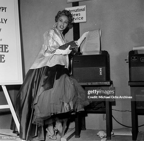 Actress Jane Powell poses with the International News Wire Service machine as she attends the premiere of "Knights of the Round Table" in Los...