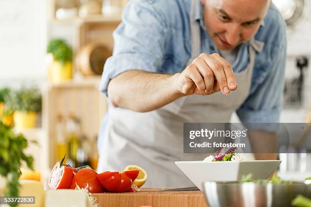 homem tempero de salada - adicionar sal imagens e fotografias de stock