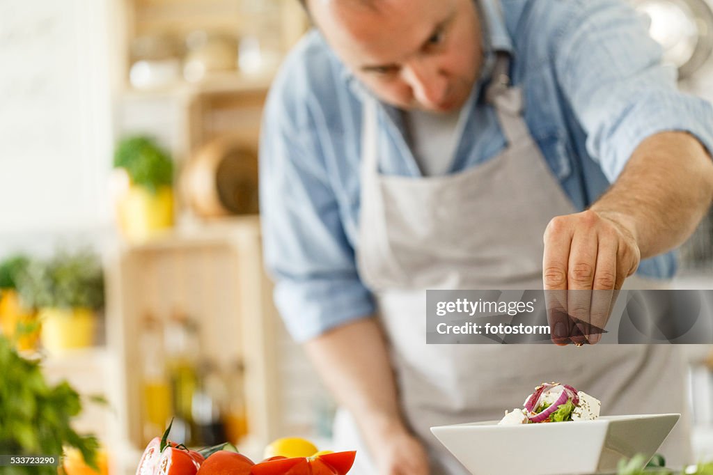 Koch dekorieren einer Platte mit gesunden Salat