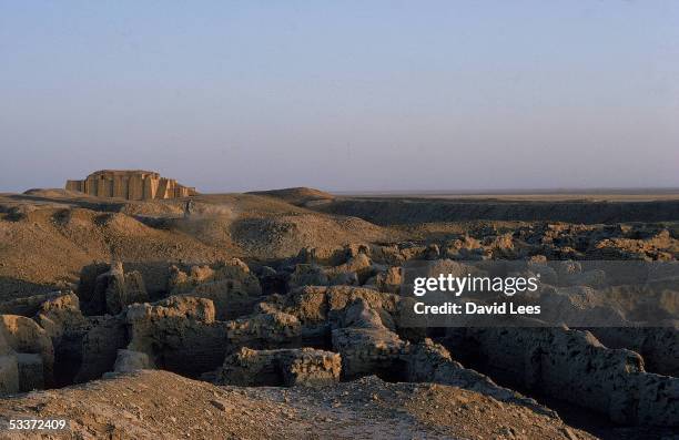 Weathered remains of a partially restored ziggurat dating from 2000 BC and the crumbling ruins of a city in the foreground at the site of the ancient...