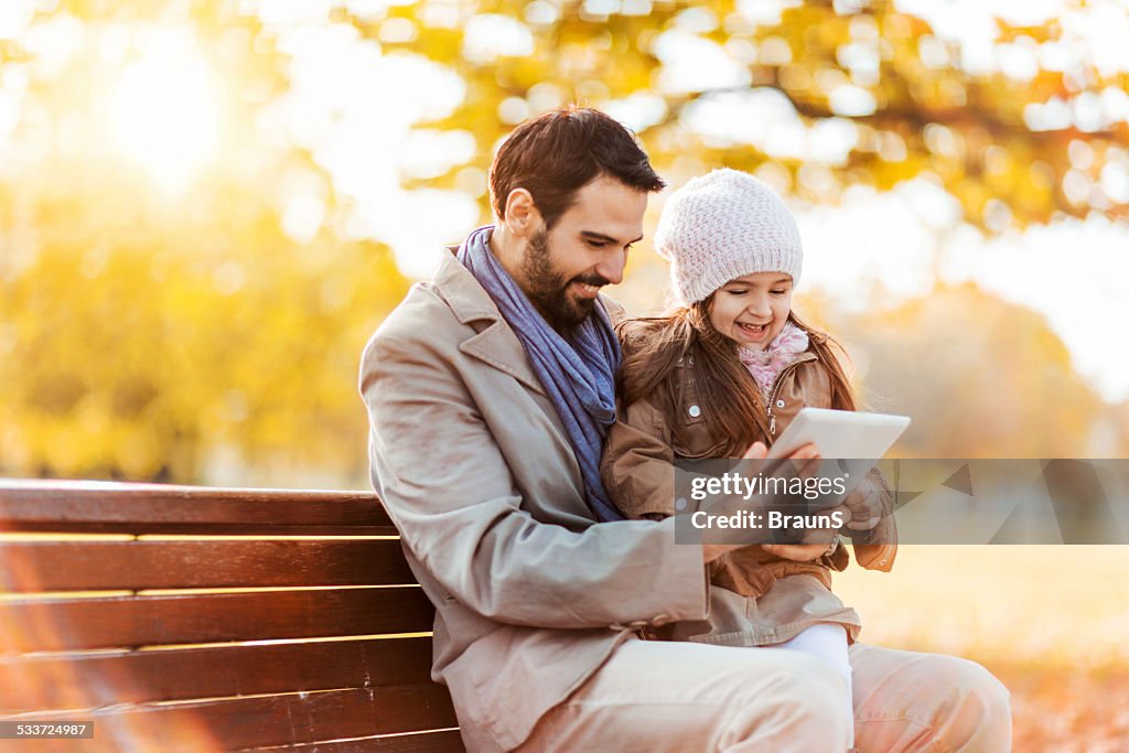 Vater und Tochter mit touchpad im Freien.