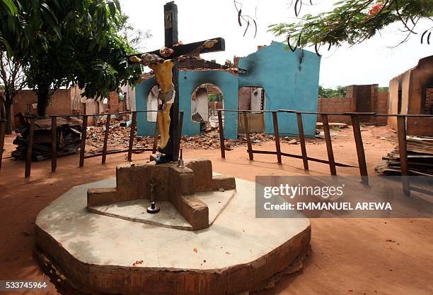 Picture taken on May 10, 2016 in Benue State, north-central Nigeria shows a burnt crucifix of Pastor James Adagaje among other residential buildings...