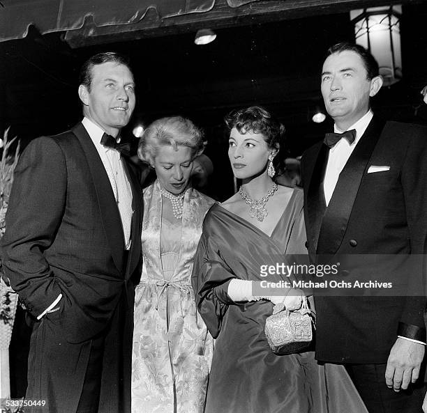 Actor Gregory Peck and his wife Veronique Passani with actor George Montgomery and singer Dinah Shore attend the premiere of "The Man in the Gray...