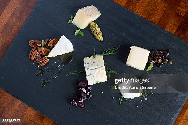 cheese and herbs on cutting board - appetizer stock pictures, royalty-free photos & images