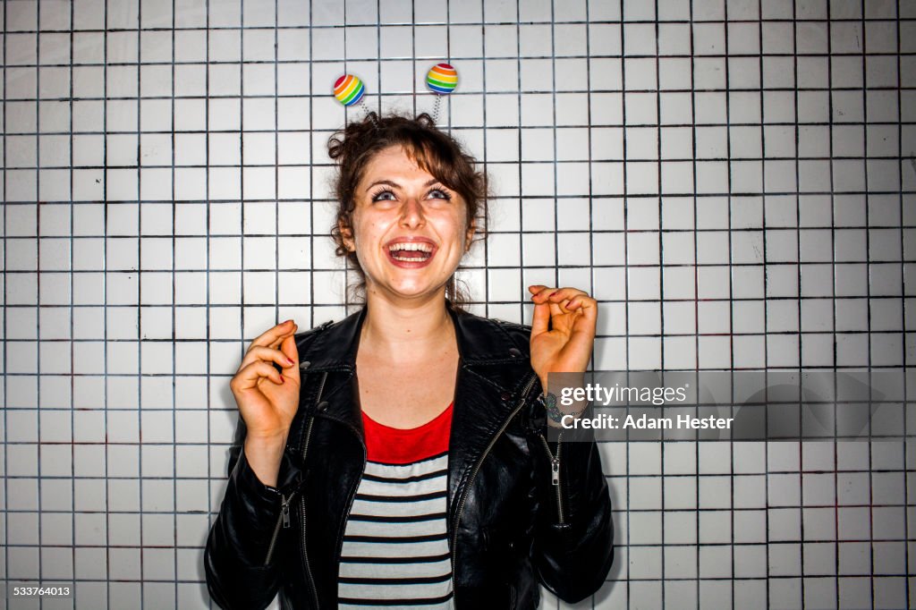 Caucasian woman wearing colorful antenna near wall