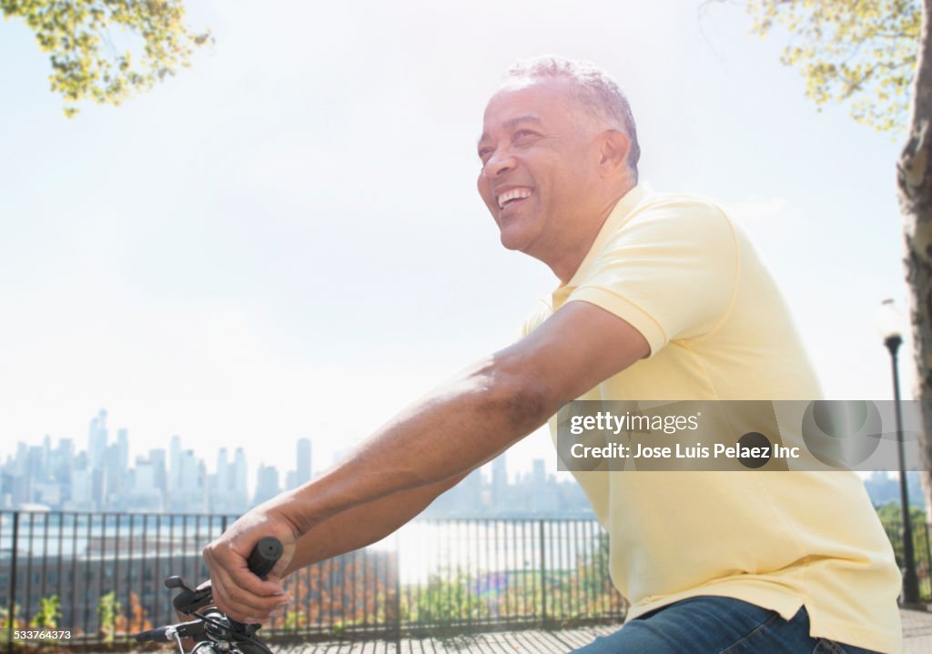 African American man riding bicycle in city park