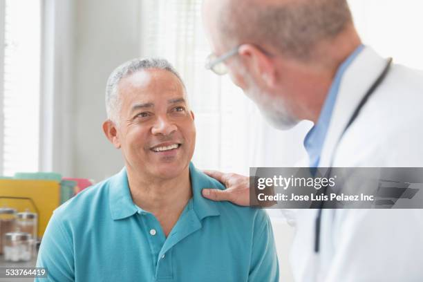 doctor talking to patient in office - 50 year old male patient stock pictures, royalty-free photos & images