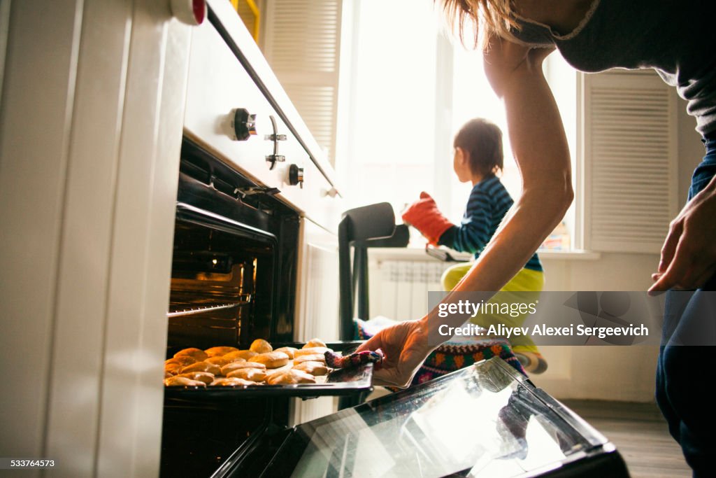 Mother and son baking cookies in kitchen