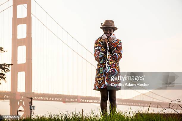 black woman wearing colorful coat by golden gate bridge, san francisco, california, united states - overcoat stock pictures, royalty-free photos & images