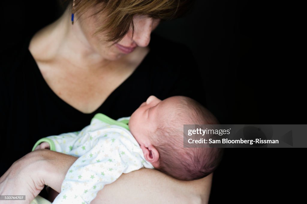 Close up of mother holding newborn baby