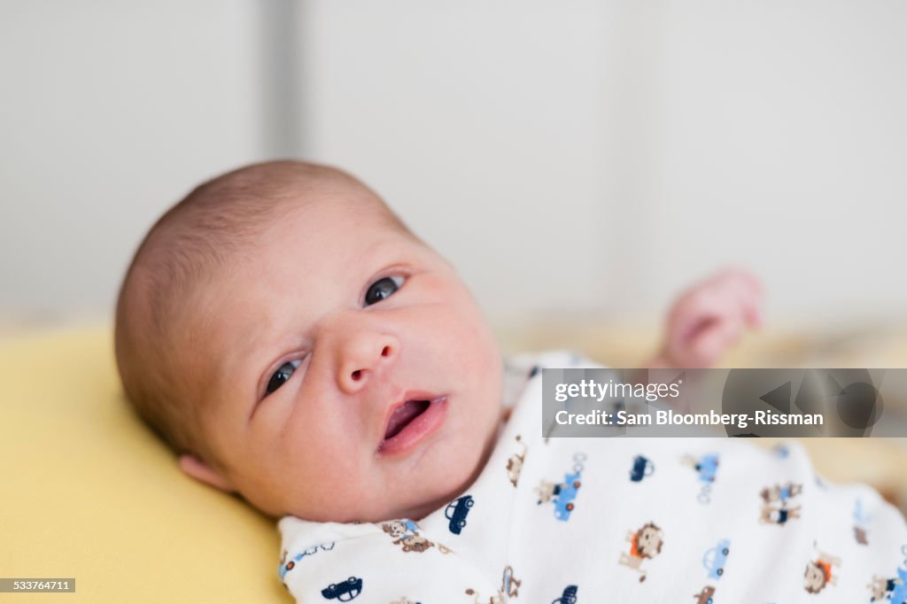 Close up of newborn mixed race baby looking at camera