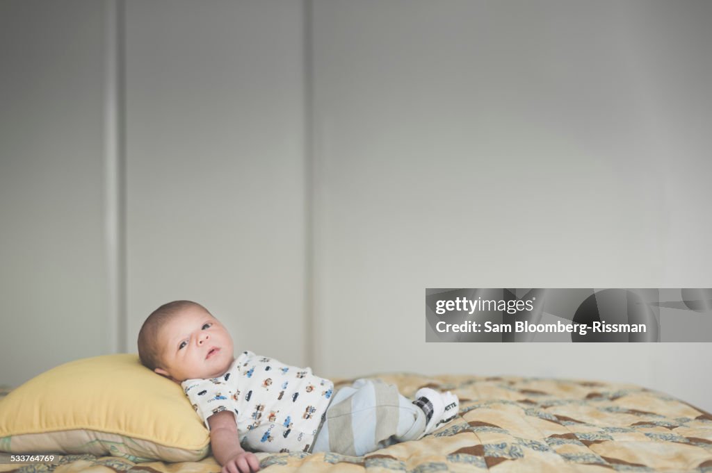 Newborn mixed race baby laying on bed