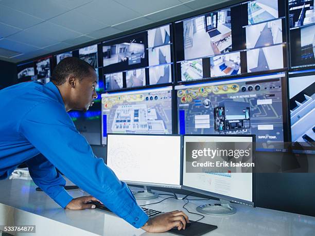 black security officer watching surveillance cameras - criminal offense stock pictures, royalty-free photos & images