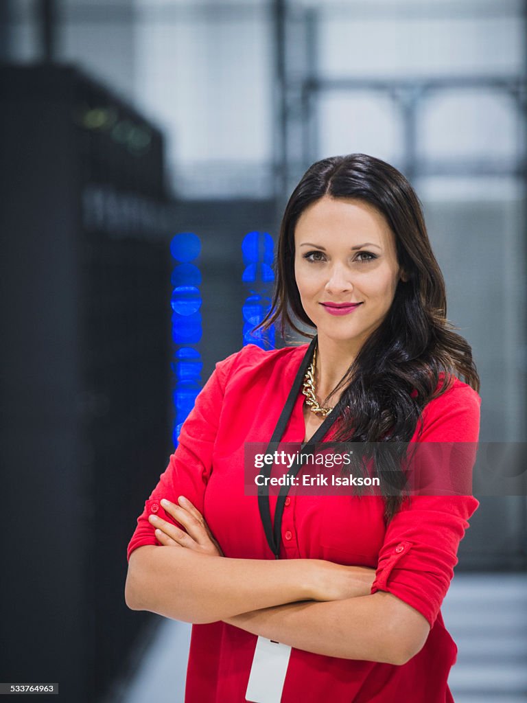 Caucasian businesswoman smiling in server room